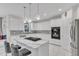 Bright white kitchen boasts marble countertops, modern pendant lighting and stainless steel appliances at 2224 Narrawood St, Raleigh, NC 27614