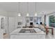 This kitchen features a large island cooktop and breakfast bar with adjacent dining and living areas at 2224 Narrawood St, Raleigh, NC 27614