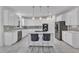 Spacious kitchen featuring white cabinets, marble countertops, stainless steel appliances and an island with bar stools at 2224 Narrawood St, Raleigh, NC 27614