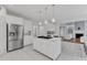Open kitchen with white cabinets, island cooktop, stainless refrigerator and access to the living room at 2224 Narrawood St, Raleigh, NC 27614