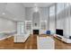 Bright living room featuring hardwood floors, fireplace, built-in shelving, and large windows with modern white furniture at 2224 Narrawood St, Raleigh, NC 27614