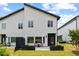 Backyard view with lawn, patio, and stylish modern home exterior under blue sky at 2225 Millbank Village Ct # 101, Raleigh, NC 27610
