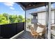 Cozy balcony with a wicker chair, black railings, and views of the surrounding trees at 2225 Millbank Village Ct # 101, Raleigh, NC 27610