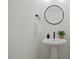 Contemporary powder room features a pedestal sink, round mirror, and modern fixtures at 2225 Millbank Village Ct # 101, Raleigh, NC 27610