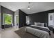Bedroom featuring an accent wall, ceiling fan, and two large windows at 2225 Millbank Village Ct # 101, Raleigh, NC 27610