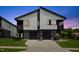 Contemporary two-story duplex featuring clean lines, gray siding, and a double garage at dusk at 2225 Millbank Village Ct # 101, Raleigh, NC 27610