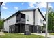 Modern home with a two-car garage, sleek black and white siding, and a covered balcony at 2225 Millbank Village Ct # 101, Raleigh, NC 27610