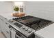 Close-up of stainless steel gas range with white countertops and subway tile backsplash at 2225 Millbank Village Ct # 101, Raleigh, NC 27610