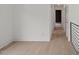 Hallway featuring white walls, hardwood floors, and black metal railing at 2225 Millbank Village Ct # 101, Raleigh, NC 27610