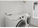 Functional laundry room with modern washer and dryer units and a window at 2225 Millbank Village Ct # 101, Raleigh, NC 27610