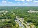 Aerial shot featuring a densely wooded neighborhood with rooftops and a distant skyline, showing the location's scenery at 225 East End Ave, Durham, NC 27703