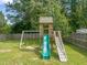 Large backyard with a wooden playset that includes a swing set, slide, and climbing ladder for outdoor fun at 225 East End Ave, Durham, NC 27703