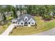 Expansive aerial view of a modern farmhouse with black trim, white exterior, and a lush green lawn at 2328 Sanctuary Dr, Raleigh, NC 27606