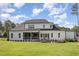 Spacious backyard with a covered porch, a fire pit area, and lush green grass, perfect for outdoor activities at 2328 Sanctuary Dr, Raleigh, NC 27606