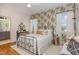 Charming bedroom with a patterned wallpaper, a metal bed frame, and an adjacent bathroom, blending comfort and style at 2328 Sanctuary Dr, Raleigh, NC 27606