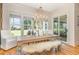 Bright dining area featuring a long wooden table, bench seating, and views of the landscaped backyard at 2328 Sanctuary Dr, Raleigh, NC 27606