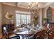 Formal dining room featuring elegant chandelier, window with view and seating for six around the oval wood table at 2328 Sanctuary Dr, Raleigh, NC 27606