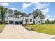 Long driveway leading to a modern farmhouse with three-car garage, lush lawn, and mature trees at 2328 Sanctuary Dr, Raleigh, NC 27606