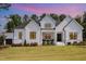 Charming white brick home with modern black-framed windows and covered porch, set against a colorful sky at 2328 Sanctuary Dr, Raleigh, NC 27606