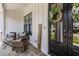 Cozy covered porch with comfortable seating, stylish decor, and a welcoming wreath on the front door at 2328 Sanctuary Dr, Raleigh, NC 27606