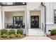 Inviting front porch with comfortable seating, double front doors, and manicured landscaping at 2328 Sanctuary Dr, Raleigh, NC 27606