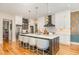 Gourmet kitchen with sleek white cabinets, stainless appliances, and a large center island with counter seating at 2328 Sanctuary Dr, Raleigh, NC 27606