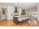 Gourmet kitchen with sleek white cabinets, stainless appliances, and a large center island with counter seating at 2328 Sanctuary Dr, Raleigh, NC 27606