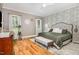 Cozy main bedroom featuring hardwood floors, neutral walls, and beautiful leaf-patterned accent wall at 2328 Sanctuary Dr, Raleigh, NC 27606