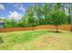 A spacious, green backyard is bordered by a wooden fence, offering privacy and a natural setting at 2619 Bordwell Grant Dr, New Hill, NC 27562