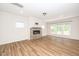 Bright living room featuring a cozy fireplace and large windows overlooking the backyard at 2619 Bordwell Grant Dr, New Hill, NC 27562