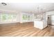Bright, open-concept living area with a kitchen island, wood floors, and ample natural light at 2619 Bordwell Grant Dr, New Hill, NC 27562
