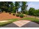 Well-maintained backyard with tiered landscaping, grass, and a black iron fence at 2661 Silver Bend Dr, Apex, NC 27539