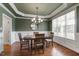 Traditional dining room with wainscoting, chandelier, and a wooden table next to window at 2661 Silver Bend Dr, Apex, NC 27539