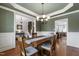 Traditional dining room with wainscoting, chandelier, and a wooden table with seating for four at 2661 Silver Bend Dr, Apex, NC 27539