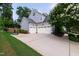 Three-car garage with white doors, ample driveway space, and a basketball hoop, great for activities at 2661 Silver Bend Dr, Apex, NC 27539