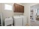 Functional laundry room with sink, dark wood cabinets, and access to other rooms at 2661 Silver Bend Dr, Apex, NC 27539