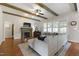 Bright living room featuring fireplace, ceiling fan, hardwood floors, and large sectional couch at 2661 Silver Bend Dr, Apex, NC 27539