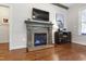 Cozy living room showcases a fireplace, hardwood floors, and a mounted television at 2661 Silver Bend Dr, Apex, NC 27539