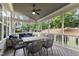 A screened porch with a ceiling fan, gray table and chairs with a view of the backyard at 2661 Silver Bend Dr, Apex, NC 27539
