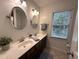 Bathroom featuring double sinks, oval mirrors, tile flooring, and natural lighting at 2708 Halfhitch Trl, Raleigh, NC 27615