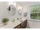 Bathroom with a dual vanity, oval mirrors, and a bright window for natural light at 2708 Halfhitch Trl, Raleigh, NC 27615