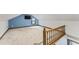 Upstairs bonus room featuring blue accent wall, carpet and staircase with natural wood railing at 2708 Halfhitch Trl, Raleigh, NC 27615