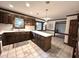 A well-lit kitchen is complete with tile flooring, wooden cabinetry, and an island with a white countertop at 2708 Halfhitch Trl, Raleigh, NC 27615