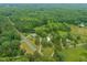 Expansive aerial view of the area, showcasing lush greenery, winding roads, and homes nestled among the trees at 2815 Orange Grove Rd, Hillsborough, NC 27278