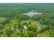 The aerial view reveals homes amidst lush greenery, roads, and a serene lake, painting a tranquil picture of the landscape at 2815 Orange Grove Rd, Hillsborough, NC 27278