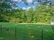 Expansive green backyard with trees and fencing, offering privacy and space at 2815 Orange Grove Rd, Hillsborough, NC 27278