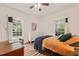 Cozy bedroom with a large window, a ceiling fan, and a wooden writing desk at 2815 Orange Grove Rd, Hillsborough, NC 27278