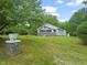Quaint home featuring mature trees and a well-manicured lawn, with a glimpse of the charming front porch at 2815 Orange Grove Rd, Hillsborough, NC 27278