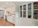 Bright kitchen with white cabinets, a stainless steel sink, and a pantry with glass doors at 2815 Orange Grove Rd, Hillsborough, NC 27278