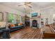Cozy living room features a brick fireplace, wood flooring, and bright windows for natural light at 2815 Orange Grove Rd, Hillsborough, NC 27278
